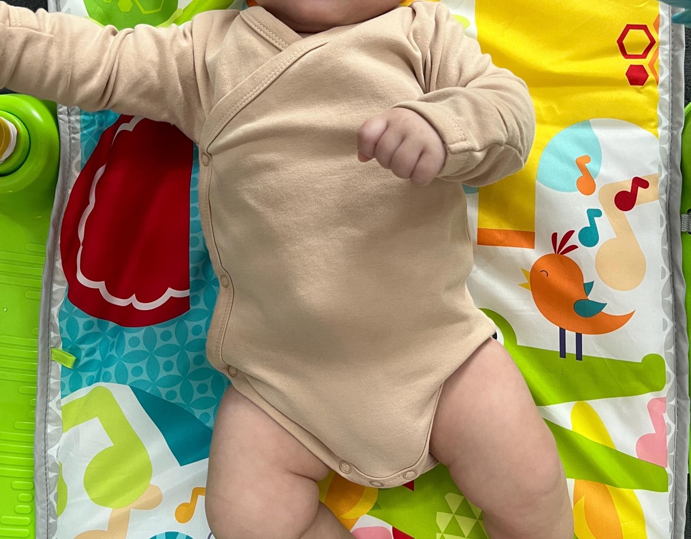 Baby on a play mat wearing the brown kimono romper